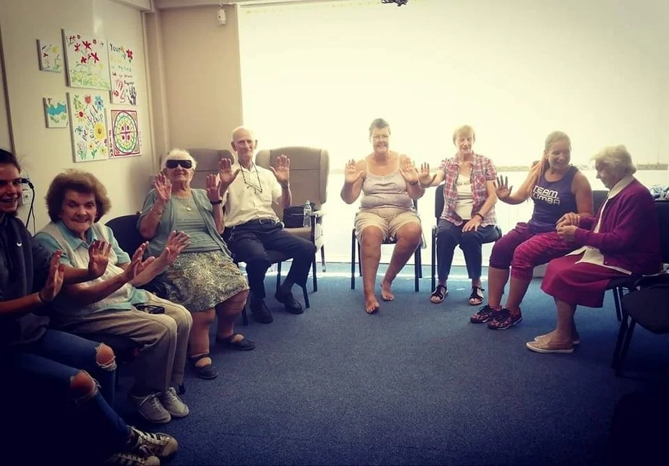 Residents enjoying a seated dance session in a care home