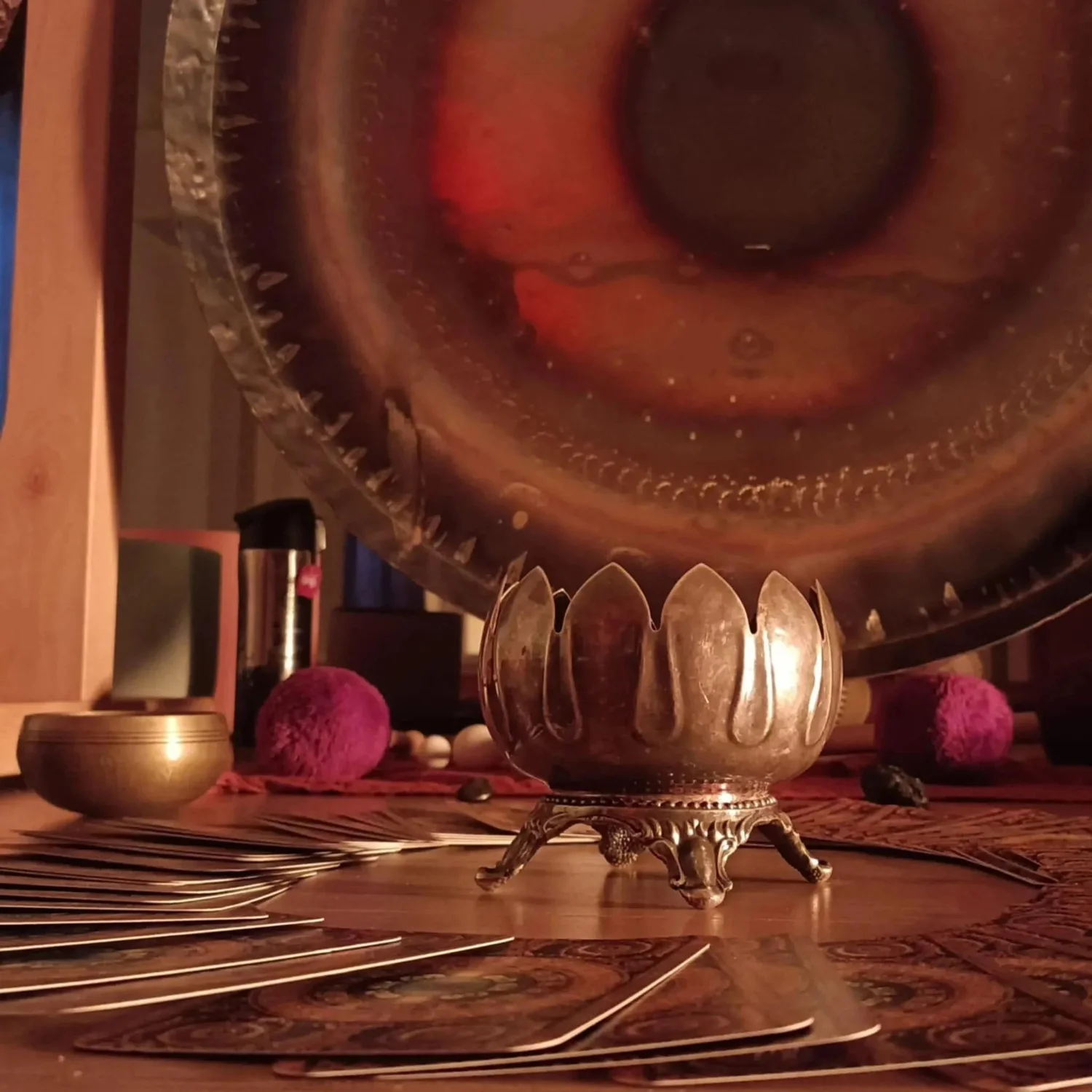 Close-up of a large gong with singing bowls in warm light