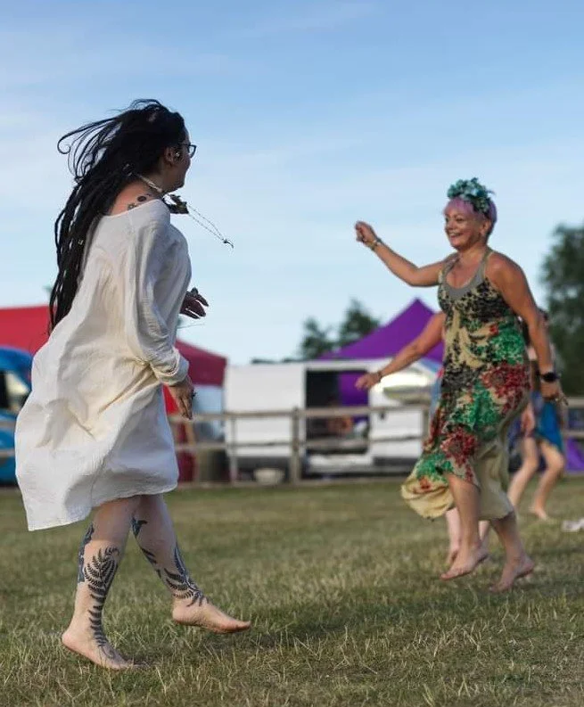 Tribe members dancing outdoors at dusk