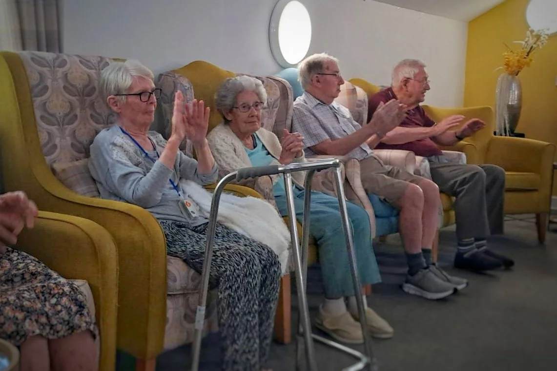 A seated movement session with residents copying gentle arm movements